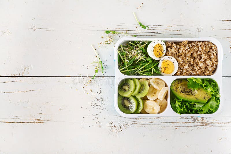 Lunchu pudełko z gotowanymi jajkami, oatmeal, avocado, mikro zieleniami i owoc, Zdrowy sprawności fizycznej jedzenie Bierze Daleko od lunchbox Odgórny widok