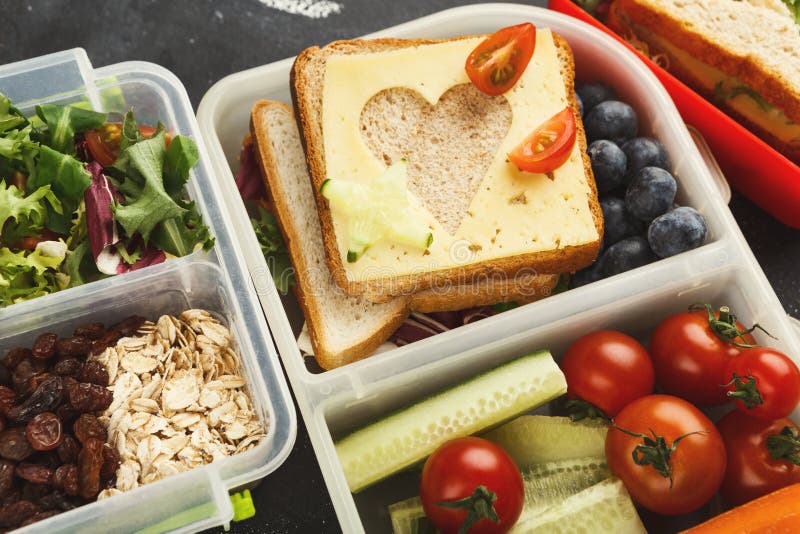 School lunch boxes for child. Healthy snacks, fruits and vegetables for dinner meals out of home. Eating right and food storage concept, closeup. School lunch boxes for child. Healthy snacks, fruits and vegetables for dinner meals out of home. Eating right and food storage concept, closeup