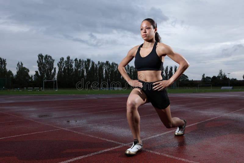 Lunge exercise for quadriceps by athlete on track