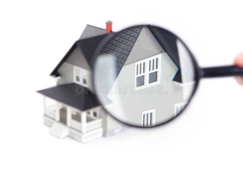 Real estate concept - hand holding magnifying glass in front of the house architectural model, isolated. Real estate concept - hand holding magnifying glass in front of the house architectural model, isolated