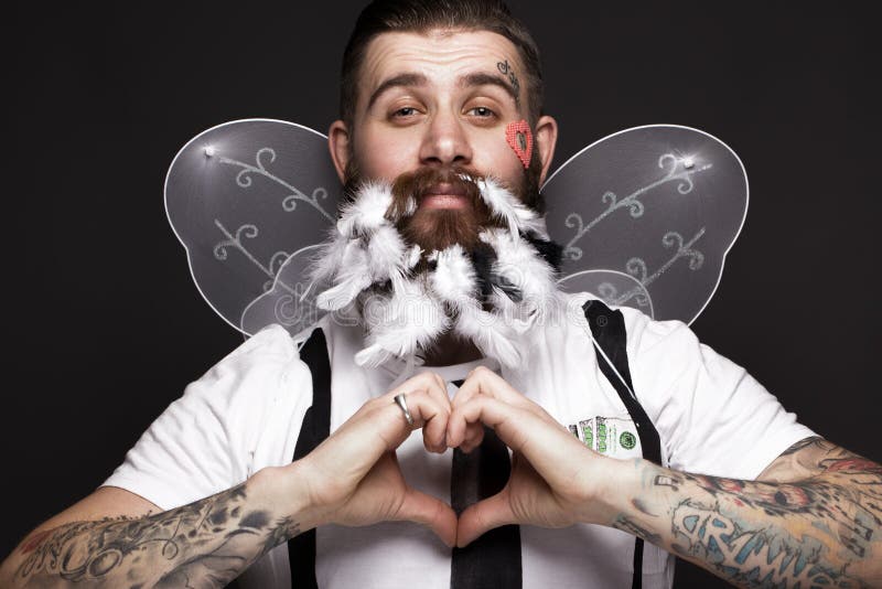 Lustiger bärtiger Mann mit Federn und Flügeln im Bild von Amor-Valentinsgruß ` s Tag lizenzfreies stockfoto Lustiger bärtiger Mann mit Federn und Flügeln im Bild von Amor-Valentinsgruß ` s Tag lizenzfreies stockfoto