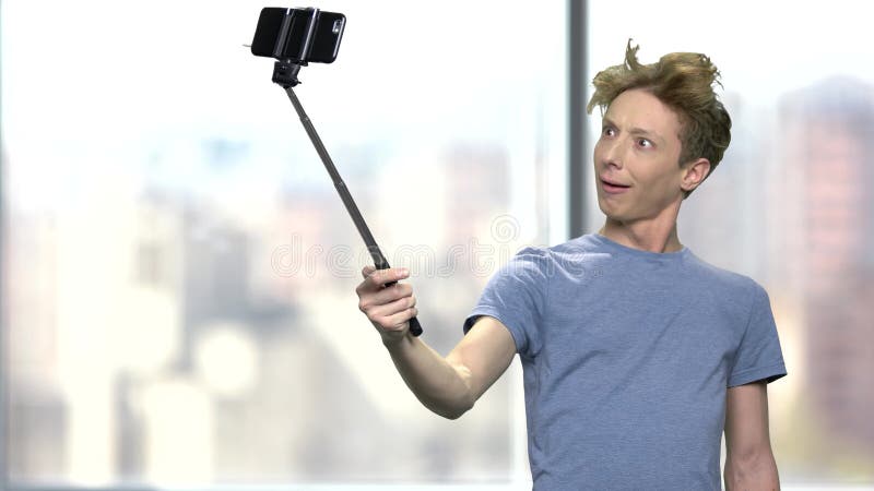 Lustiger Jugendlichjunge, der monopod verwendet