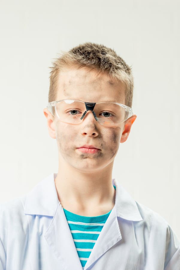 Lustiger Junge gekleidet als Chemiker mit schmutzigen Gesicht nach stockfotografie