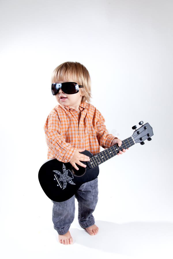 Lustiger kleiner Junge mit Ukulelegitarre stockfotografie Lustiger kleiner Junge mit Ukulelegitarre stockfotografie