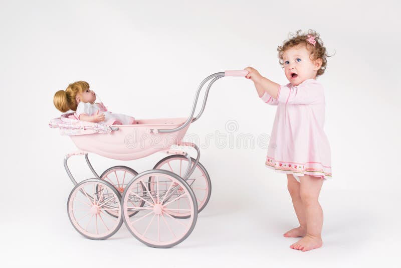 Lustiges Baby, das mit einem Puppenspaziergänger geht stockfotos Lustiges Baby, das mit einem Puppenspaziergänger geht stockfotos
