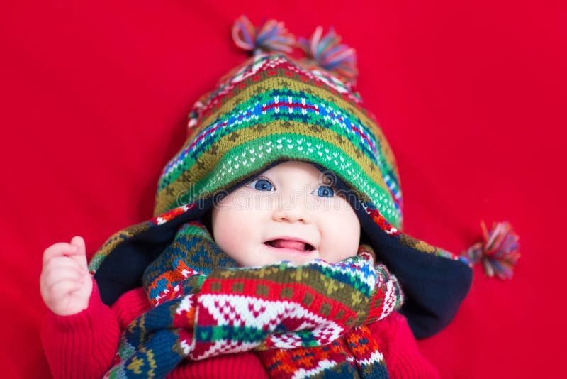 Lustiges Baby in der bunten Strickmütze und im Schal stockfotos