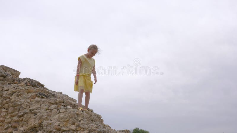 Lustiges Jugendlichmädchen, das unten auf alte Treppe des Felsens geht