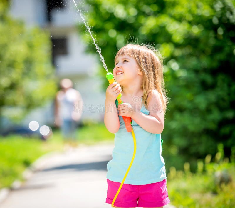 Entzückendes Kleines Mädchen, Das Mit Wasserwerfer am Heißen