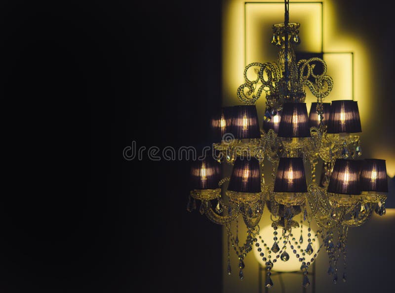 Lustre chic cher sur le fond noir Lustre avec rougeoyer chaud dans intérieur foncé, defocused Lustre avec beaucoup de lampes et d'atmosphère intime Allumage et concept mystérieux de l'atmosphère