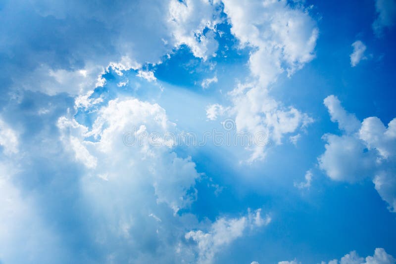 Lustro di Sunbeam attraverso la nuvola sul cielo blu