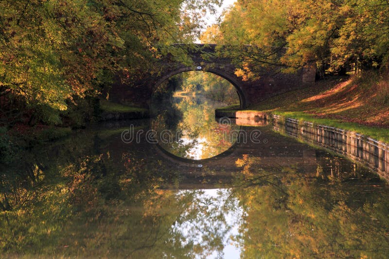 Lustrzany odbicie Łukowaci mosta i jesieni drzewa w Uroczystym Zrzeszeniowym kanale