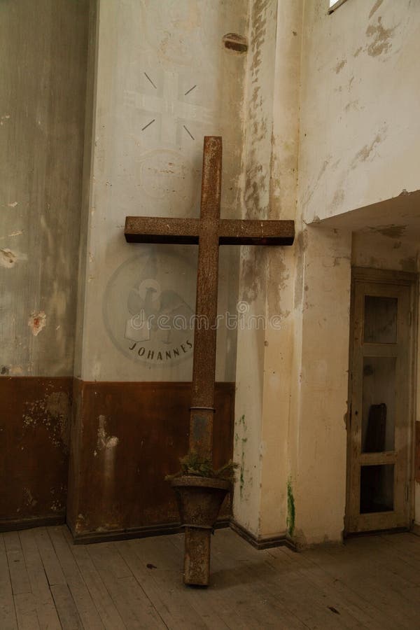 Lutheran metal large cross in the corner of the church. Abandoned Lutheran Church