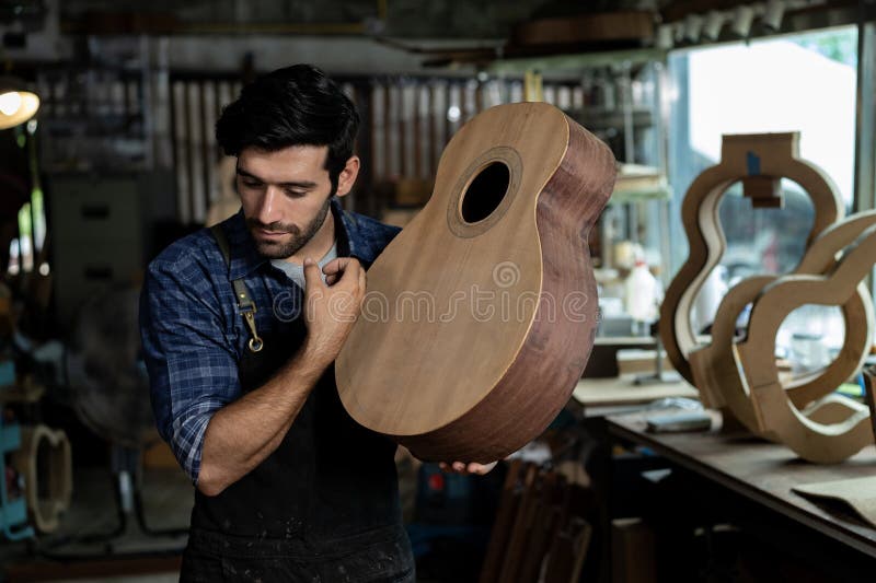 Luthier Taps Spruce Top of Unfinished Acoustic Guitar to Check Sound Quality