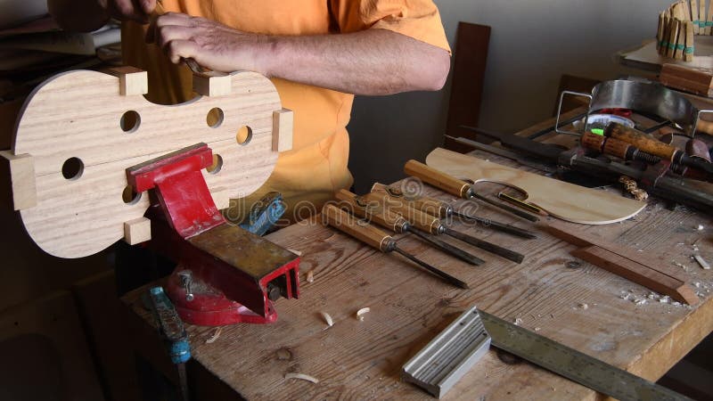 Luthier που εργάζεται με σμίλη σε νέο βιολί ή βιολί στο χώρο εργασίας