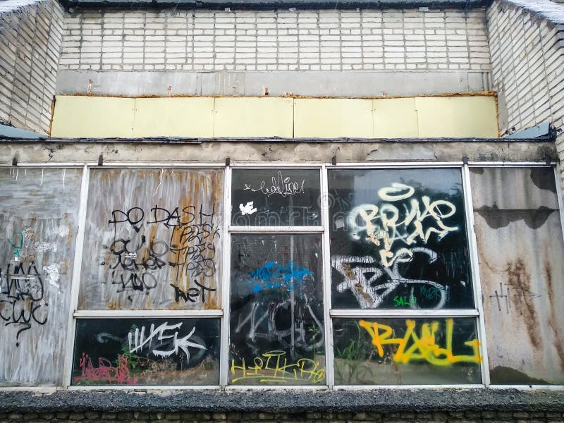 Lutsk ukraine får 30 2020. Målad vägg av gammal byggnad i staden. graffiti på fönster i övergivna hus. Märkning på glas royaltyfria foton