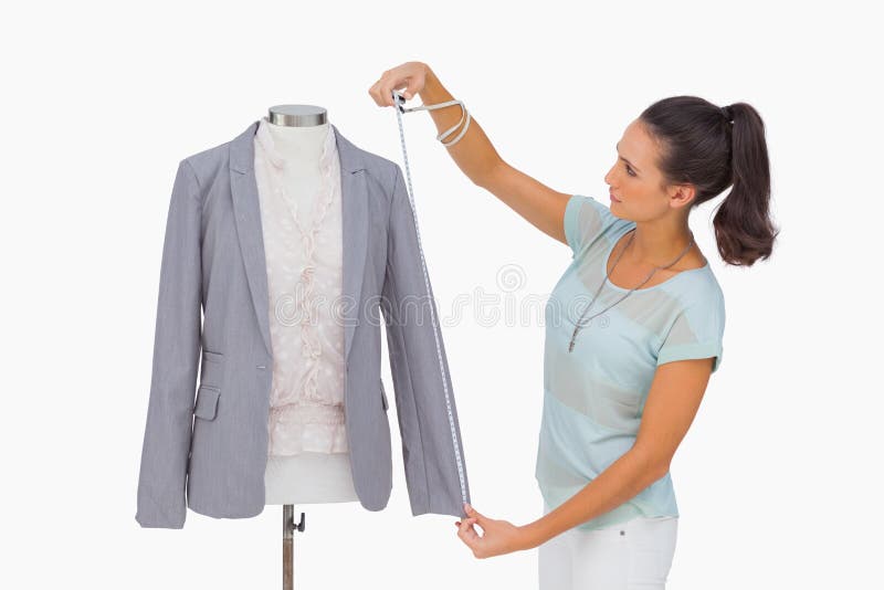 Luva de medição do blazer do desenhador de moda no manequim imagens de stock royalty free Luva de medição do blazer do desenhador de moda no manequim imagens de stock royalty free