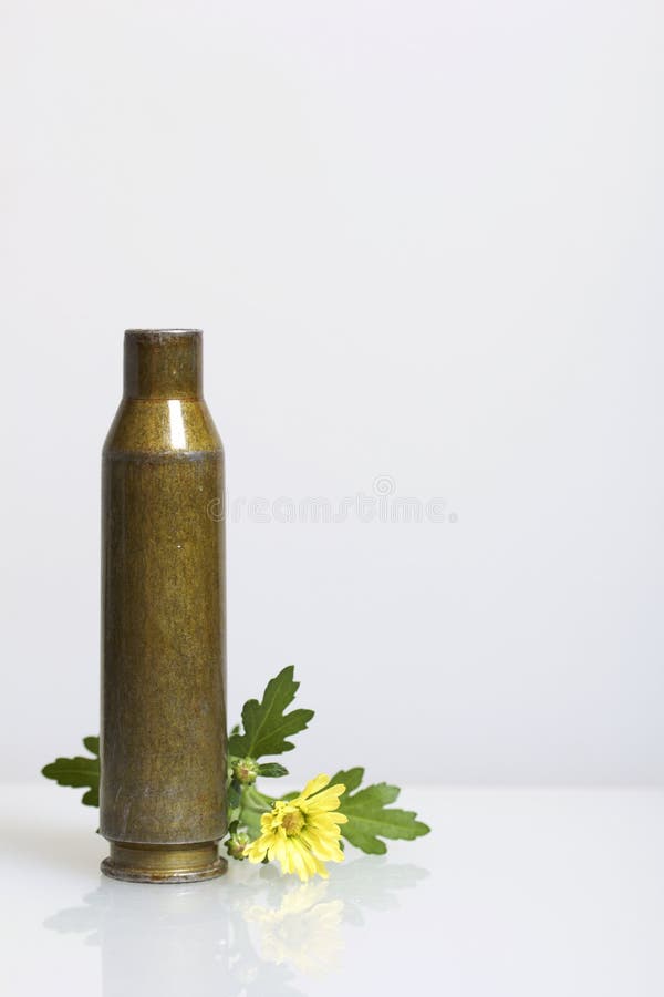 A luva do tiro de uma metralhadora do grande-calibre e um crisântemo amarelo florescem Estabelecimento da paz foto de stock A luva do tiro de uma metralhadora do grande-calibre e um crisântemo amarelo florescem Estabelecimento da paz foto de stock