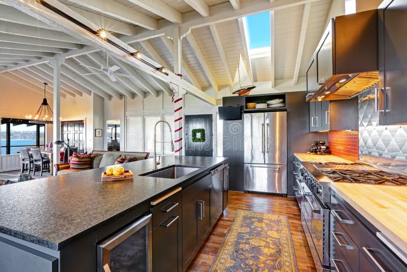 Luxe mooie donkere moderne keuken met gewelfd houten plafond stock afbeeldingen Luxe mooie donkere moderne keuken met gewelfd houten plafond stock afbeeldingen