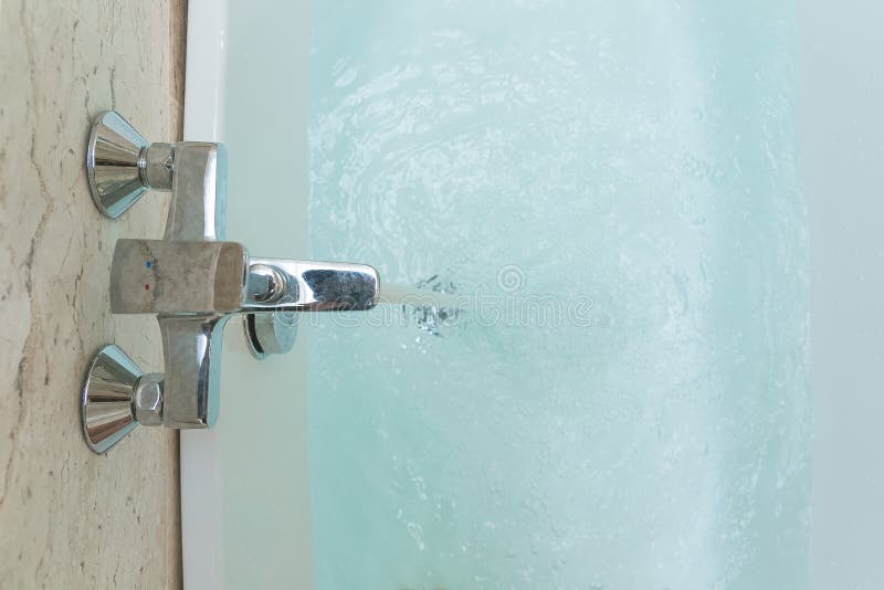 Luxueuze badkuip en kraan met water stock afbeelding Luxueuze badkuip en kraan met water stock afbeelding