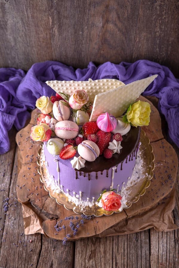 Luxueuze Purpere die cake met een bise, een heemst, bessen en verse bloemen wordt verfraaid royalty-vrije stock afbeelding Luxueuze Purpere die cake met een bise, een heemst, bessen en verse bloemen wordt verfraaid royalty-vrije stock afbeelding