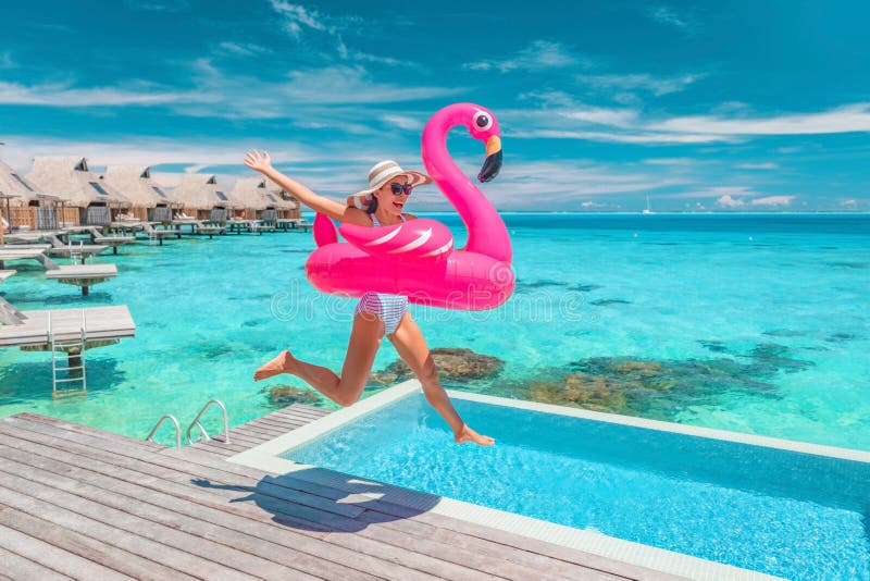 Luxuoso hotel praia férias oceano água sobre bungalows resort. mulher feliz saltando de alegria em um brinquedo de piscina engraça