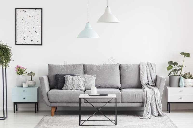 Luxuriöser Wohnzimmerinnenraum mit einer grauen Couch, Lampen, Kaffee