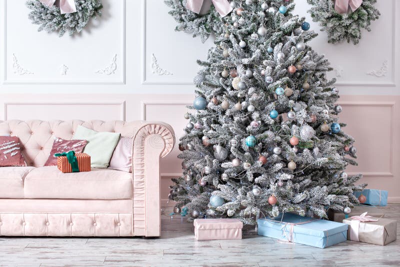 Luxuriöses Wohnzimmer mit Sofa dekoriert schicke Weihnachtsbaum, Geschenke und Kissen Klassisches Interieur in rosa Farbtönen Wei stockfotografie Luxuriöses Wohnzimmer mit Sofa dekoriert schicke Weihnachtsbaum, Geschenke und Kissen Klassisches Interieur in rosa Farbtönen Wei stockfotografie
