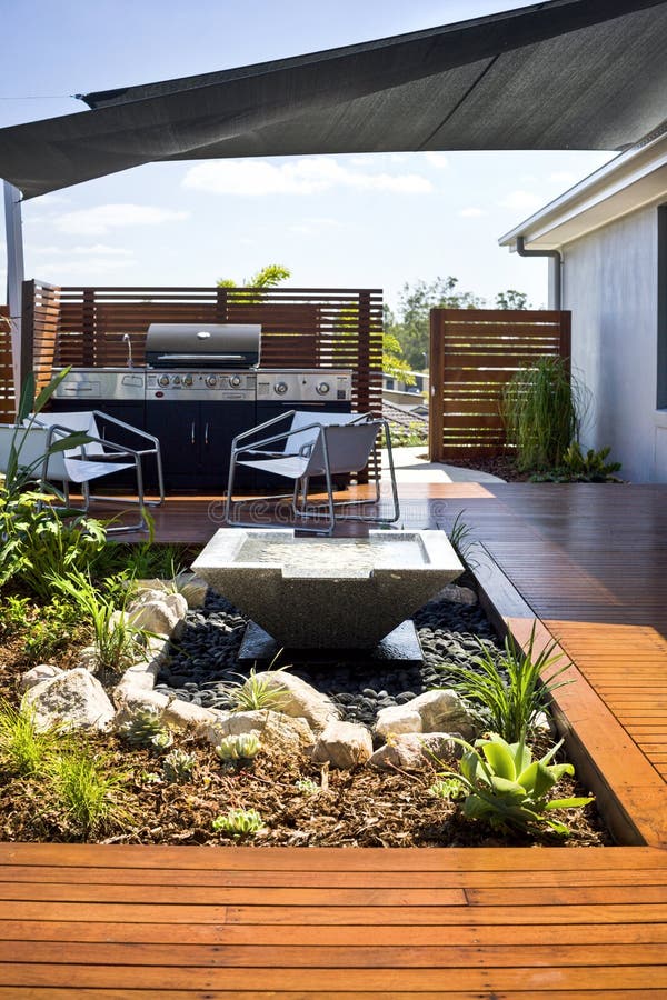 A luxury backyard home garden with lounge space. On wooden decking. High quality photo