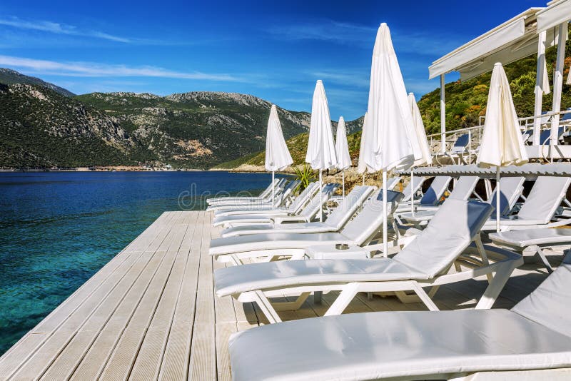 Luxury beach with white sun loungers and umbrellas. Great place to stay royalty free stock image Luxury beach with white sun loungers and umbrellas. Great place to stay royalty free stock image