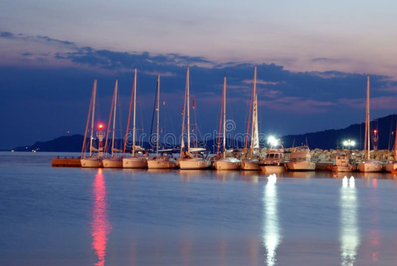 Luxury boats aligned near the dam in night