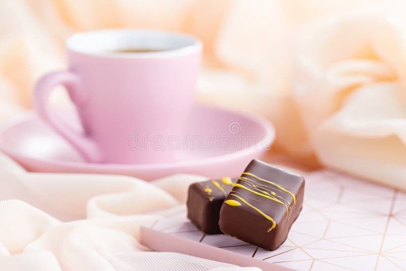 Luxury bonbons with cup of coffee on pastel pink background royalty free stock photography Luxury bonbons with cup of coffee on pastel pink background royalty free stock photography