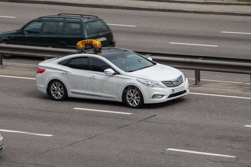 Luxury car white hyundai taxi speeding on empty highway stock photography Luxury car white hyundai taxi speeding on empty highway stock photography