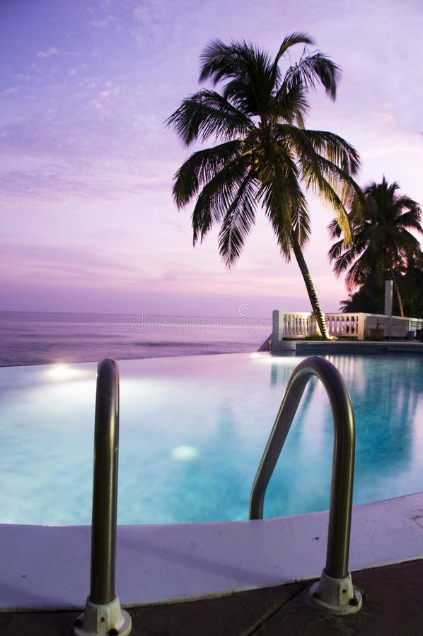 Luxury infinity swimming pool caribbean sunset