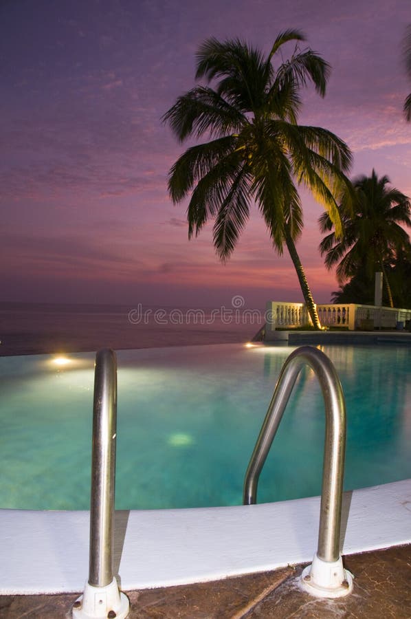 Luxury infinity swimming pool caribbean sunset