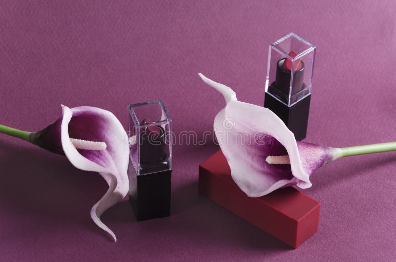 Elegant lipsticks with flower decoration on the purple background stock photography Elegant lipsticks with flower decoration on the purple background stock photography