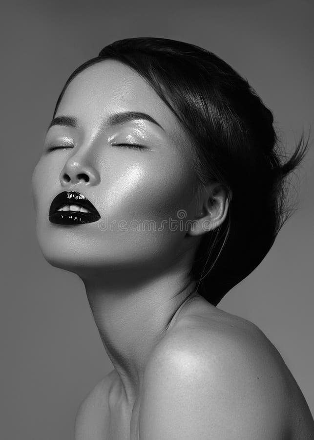 Dramatic black and white fashion portrait of beautiful asian woman. Luxury oriental model with great make-up, smooth skin, gloss lips and perfect hairstyle. Elegant evening look. Dramatic black and white fashion portrait of beautiful asian woman. Luxury oriental model with great make-up, smooth skin, gloss lips and perfect hairstyle. Elegant evening look