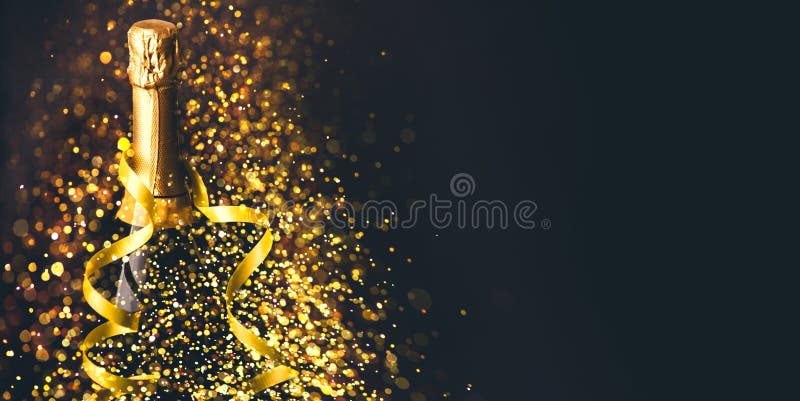 Luxury new year background. Champagne bottle with gold ribbon on dark background with golden bokeh glitter firework. Christmas