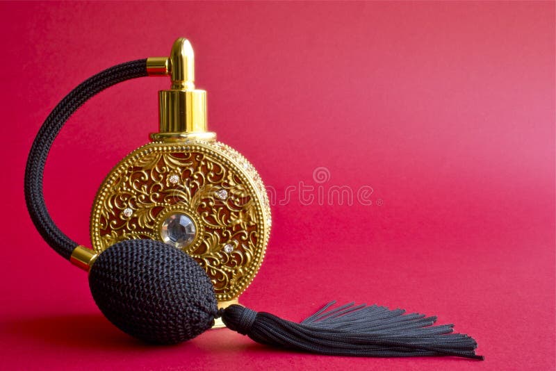 A close-up shot of a gold luxury perfume bottle.