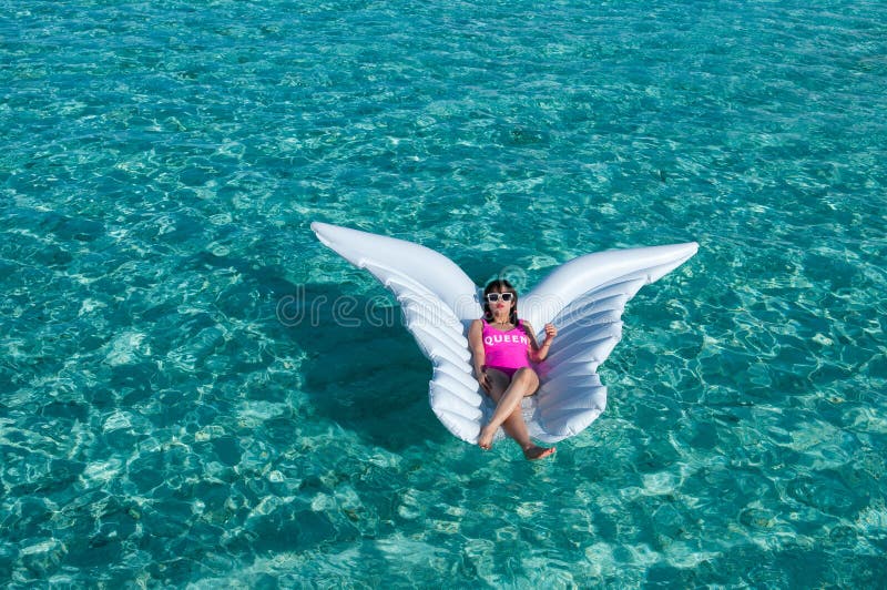 Luxury summer vacation beach woman relaxing lying down on inflatable pool float floating at Maldives sun tanning. Model sleeping o royalty free stock photography Luxury summer vacation beach woman relaxing lying down on inflatable pool float floating at Maldives sun tanning. Model sleeping o royalty free stock photography