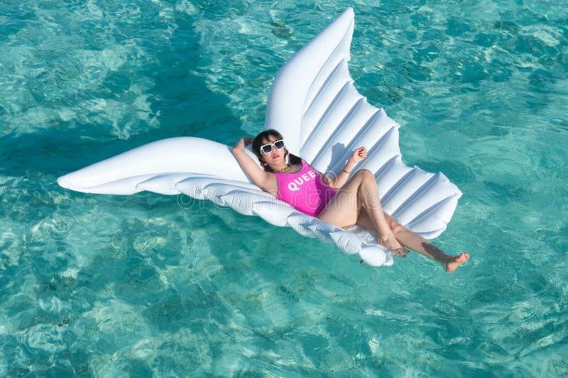 Luxury summer vacation beach woman relaxing lying down on inflatable pool float floating at Maldives sun tanning. Model sleeping o royalty free stock photography Luxury summer vacation beach woman relaxing lying down on inflatable pool float floating at Maldives sun tanning. Model sleeping o royalty free stock photography