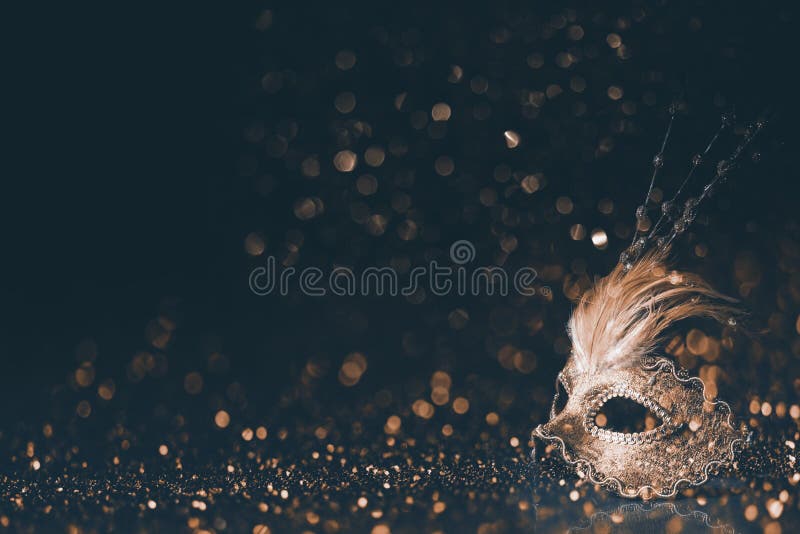 Luxury venetian mask on dark godlen bokeh background. New year and christmas party celebration design banner. Carnival masquerade fantasy costume ball. Luxury venetian mask on dark godlen bokeh background. New year and christmas party celebration design banner. Carnival masquerade fantasy costume ball