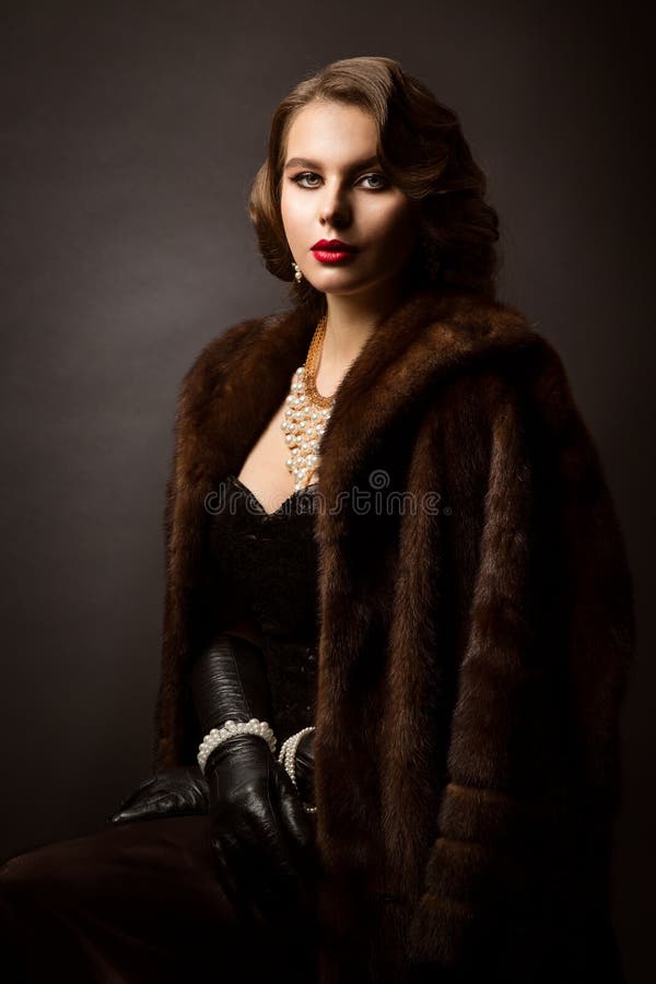 Luxury Woman in Fur Coat, Fashion Model Beauty Portrait, Old Fashioned Well Dressed Lady, over studio black background. Luxury Woman in Fur Coat, Fashion Model Beauty Portrait, Old Fashioned Well Dressed Lady, over studio black background
