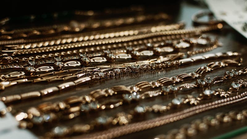 Luxusgoldschmuckketten, Armbandhintergrund, selektiver Fokus Stilvolles schönes bijouterie, das am Stand in hängt lizenzfreie stockfotografie Luxusgoldschmuckketten, Armbandhintergrund, selektiver Fokus Stilvolles schönes bijouterie, das am Stand in hängt lizenzfreie stockfotografie
