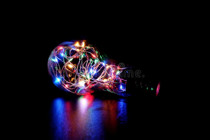 Luz de hadas colorida en un tarro de cristal formado de la bombilla imagen de archivo libre de regalías Luz de hadas colorida en un tarro de cristal formado de la bombilla imagen de archivo libre de regalías