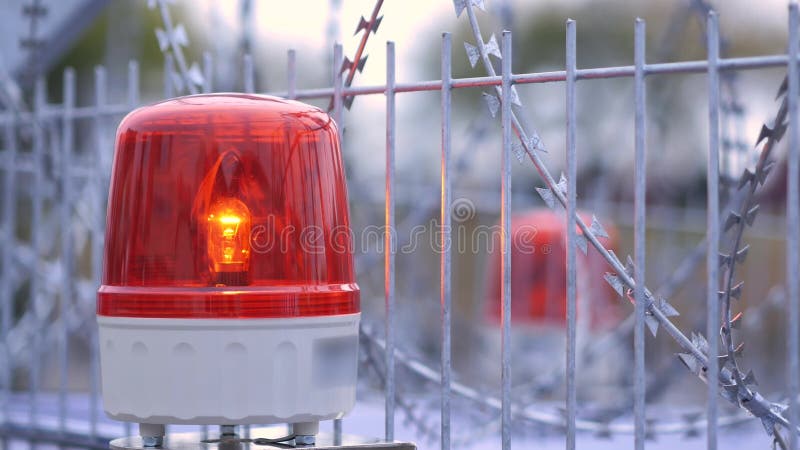 Luz de la sirena de señal de emergencia roja que gira en la valla alambrada Cerrar