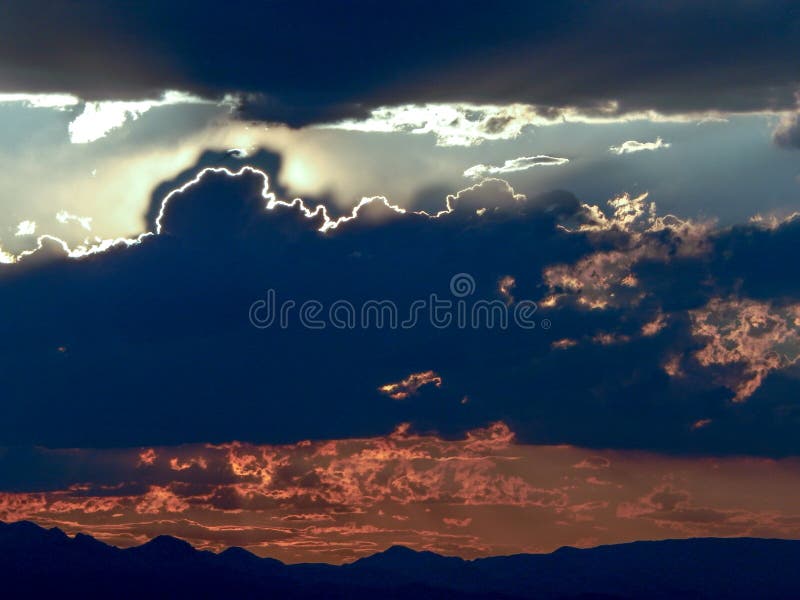 Luz de Sun que espreita atrás das nuvens escuras fotografia de stock royalty free Luz de Sun que espreita atrás das nuvens escuras fotografia de stock royalty free