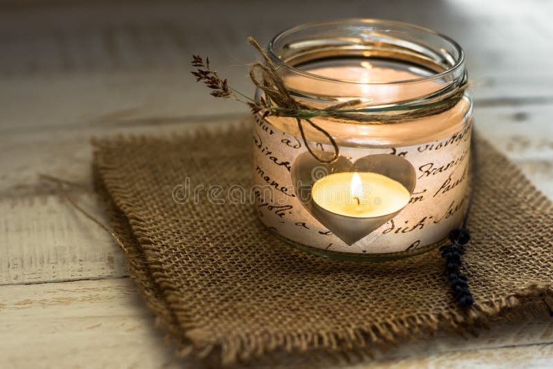 Luz del té en candelero en forma de corazón del tarro con la ramita de la guita y de la lavanda, tarjeta del día de San Valentín, fotografía de archivo libre de regalías Luz del té en candelero en forma de corazón del tarro con la ramita de la guita y de la lavanda, tarjeta del día de San Valentín, fotografía de archivo libre de regalías
