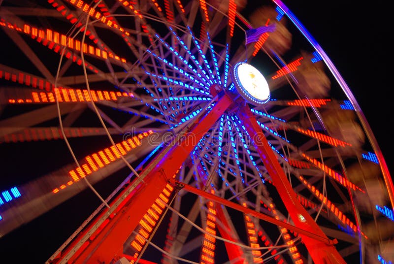Luzes coloridas da roda de Ferris na noite imagem de stock royalty free Luzes coloridas da roda de Ferris na noite imagem de stock royalty free