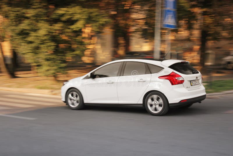 Lviv, de Oekraïne - Augustus 23, 2018: Witte auto Ford Focus in motie stock foto Lviv, de Oekraïne - Augustus 23, 2018: Witte auto Ford Focus in motie stock foto