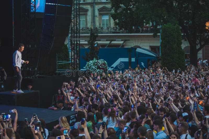 LVIV, UCRÂNIA - 18 de junho de 2019: cantor da estrela do rock na fase na frente da multidão fotografia de stock LVIV, UCRÂNIA - 18 de junho de 2019: cantor da estrela do rock na fase na frente da multidão fotografia de stock